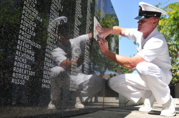 A man making a rubbing of the wall